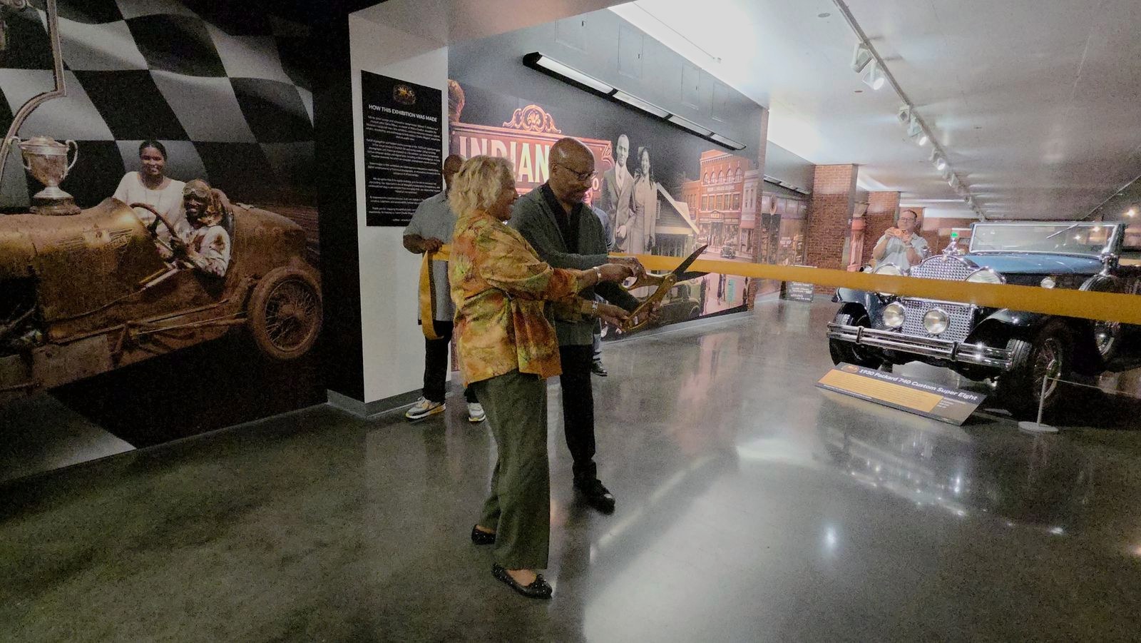 Cutting the ribbon to open the exhibition.