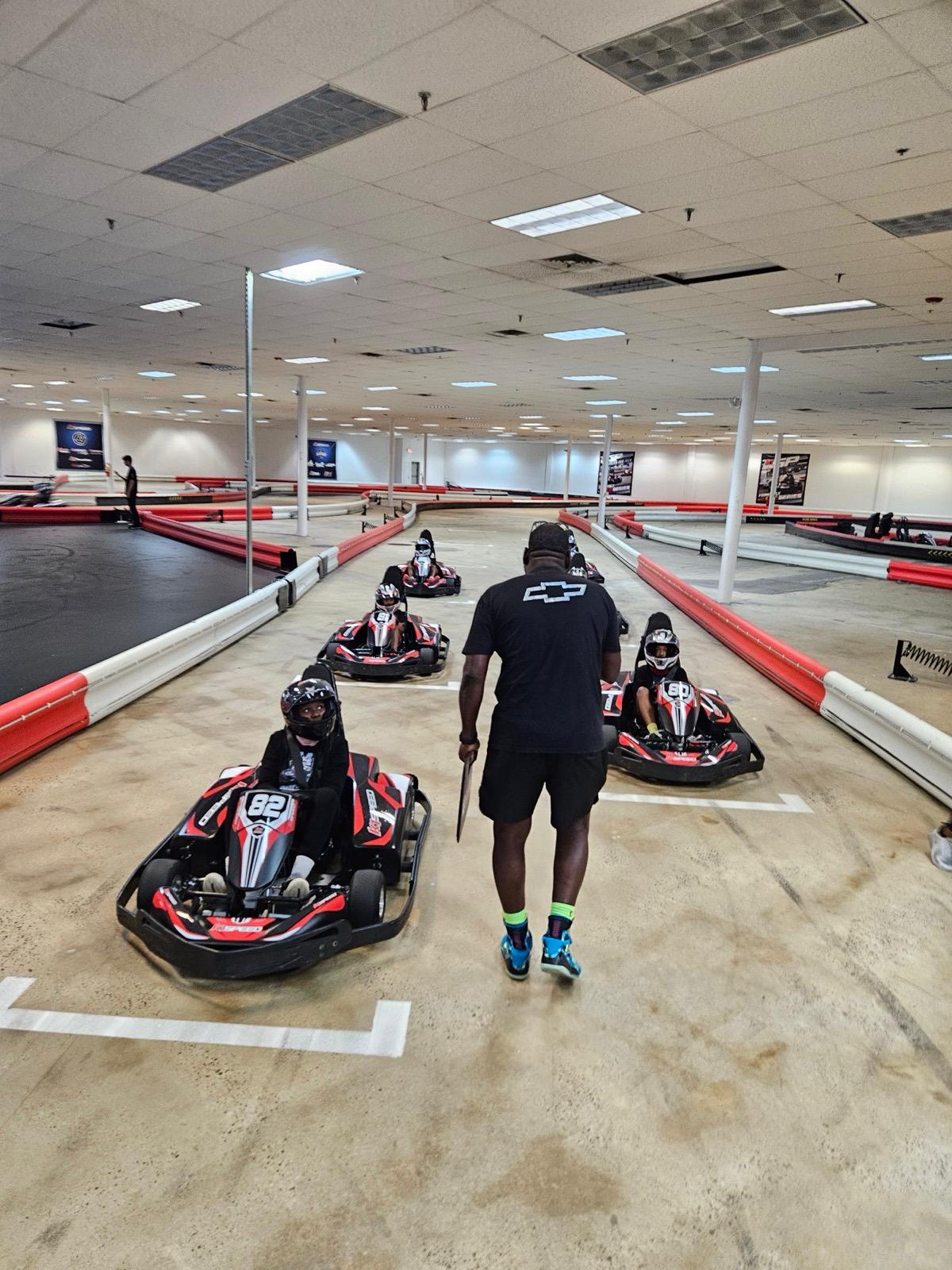 UYRS instructor coaching young drivers on the go-kart track