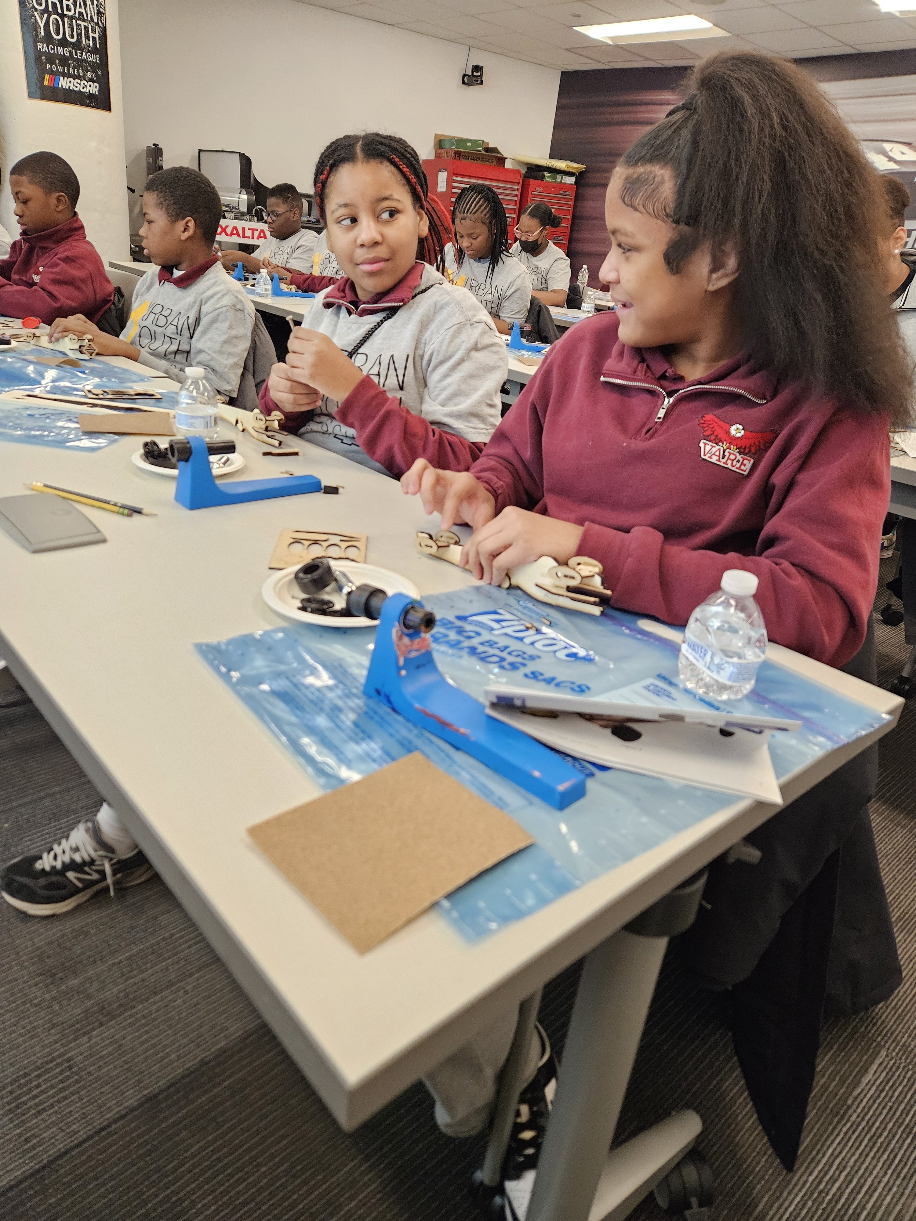 UYRS volunteers and mentors working with students on a hands-on STEM activity